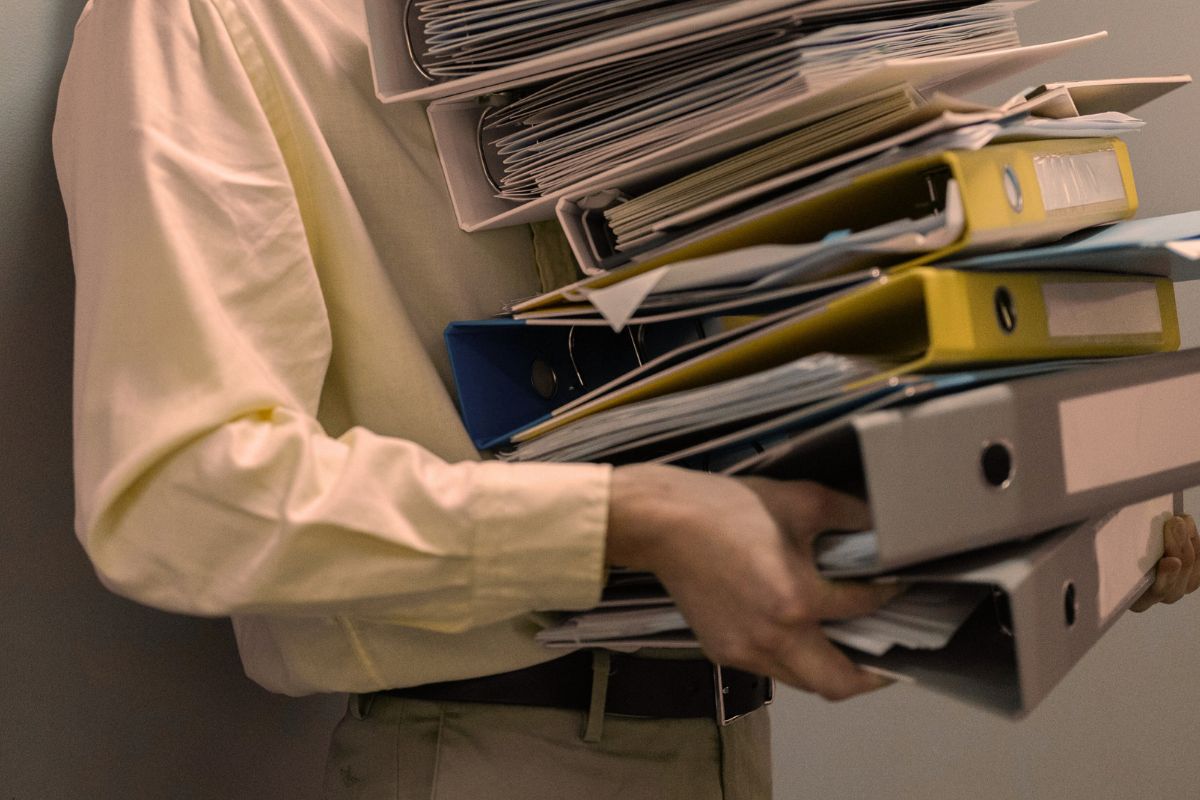 Person is carrying a large amount of files.