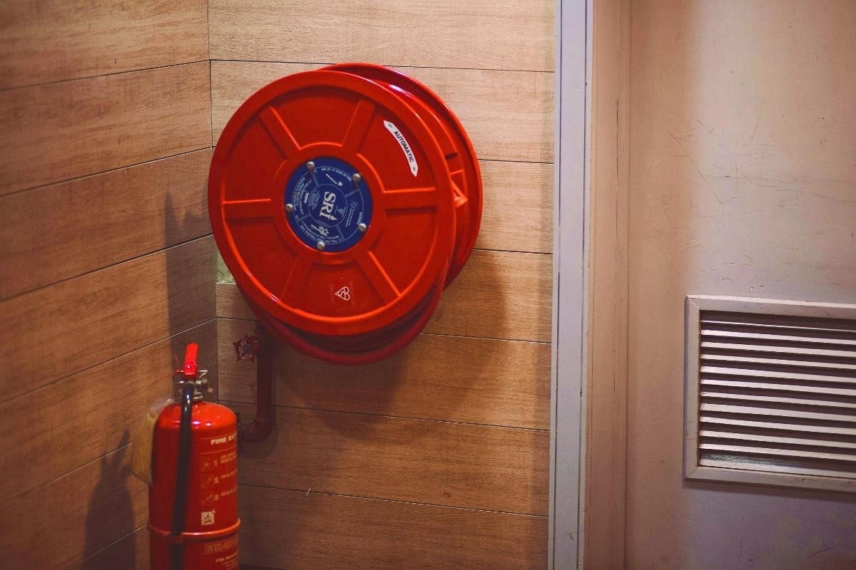 Fire extinguisher and hose reel on office wall indicating a building with good fire safety. 